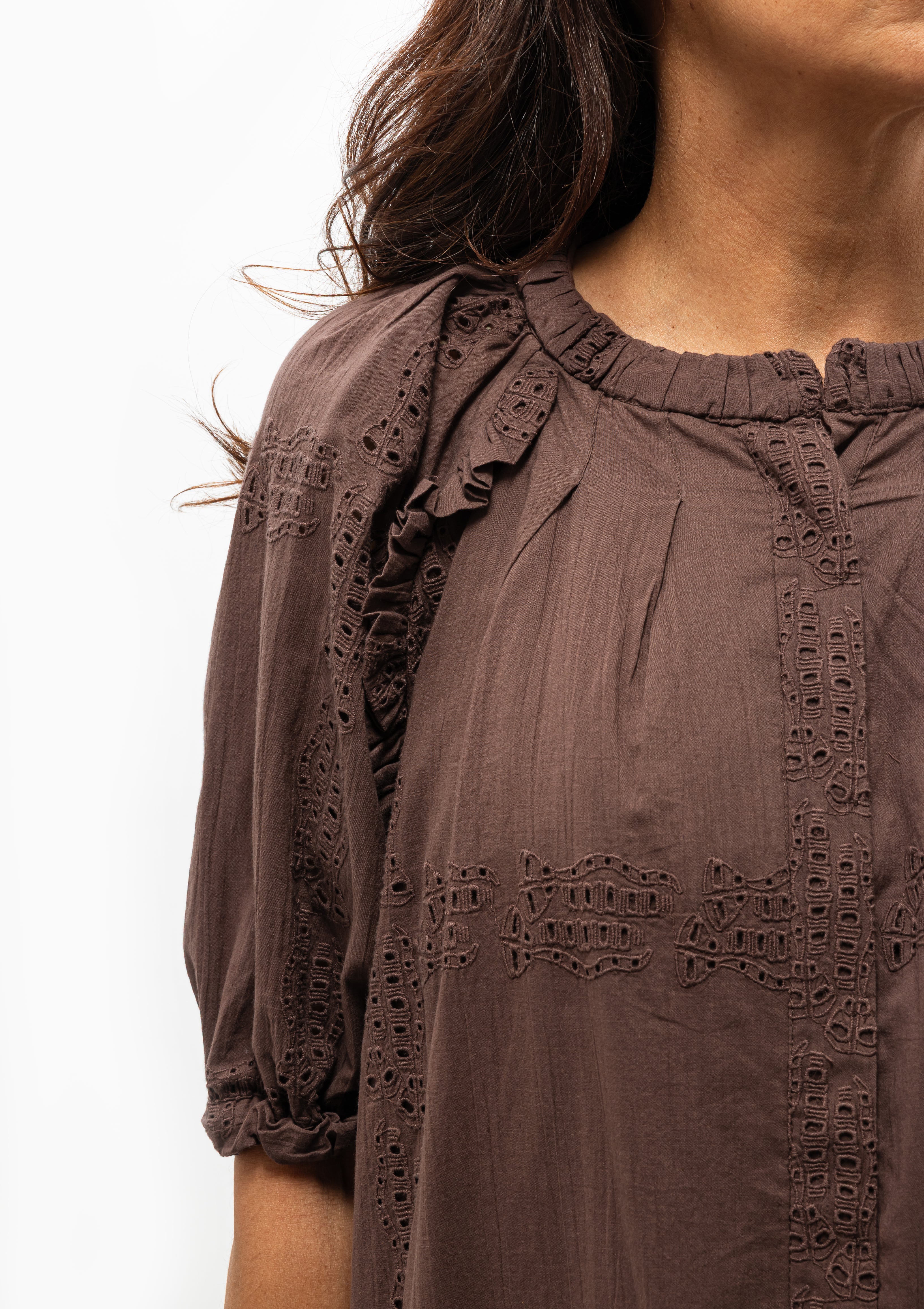 Charming and breezy, the Sommerset Dress in Grappa, its intricate eyelets, delicate ruffling, and soft ruching. Available at Diani Boutique.