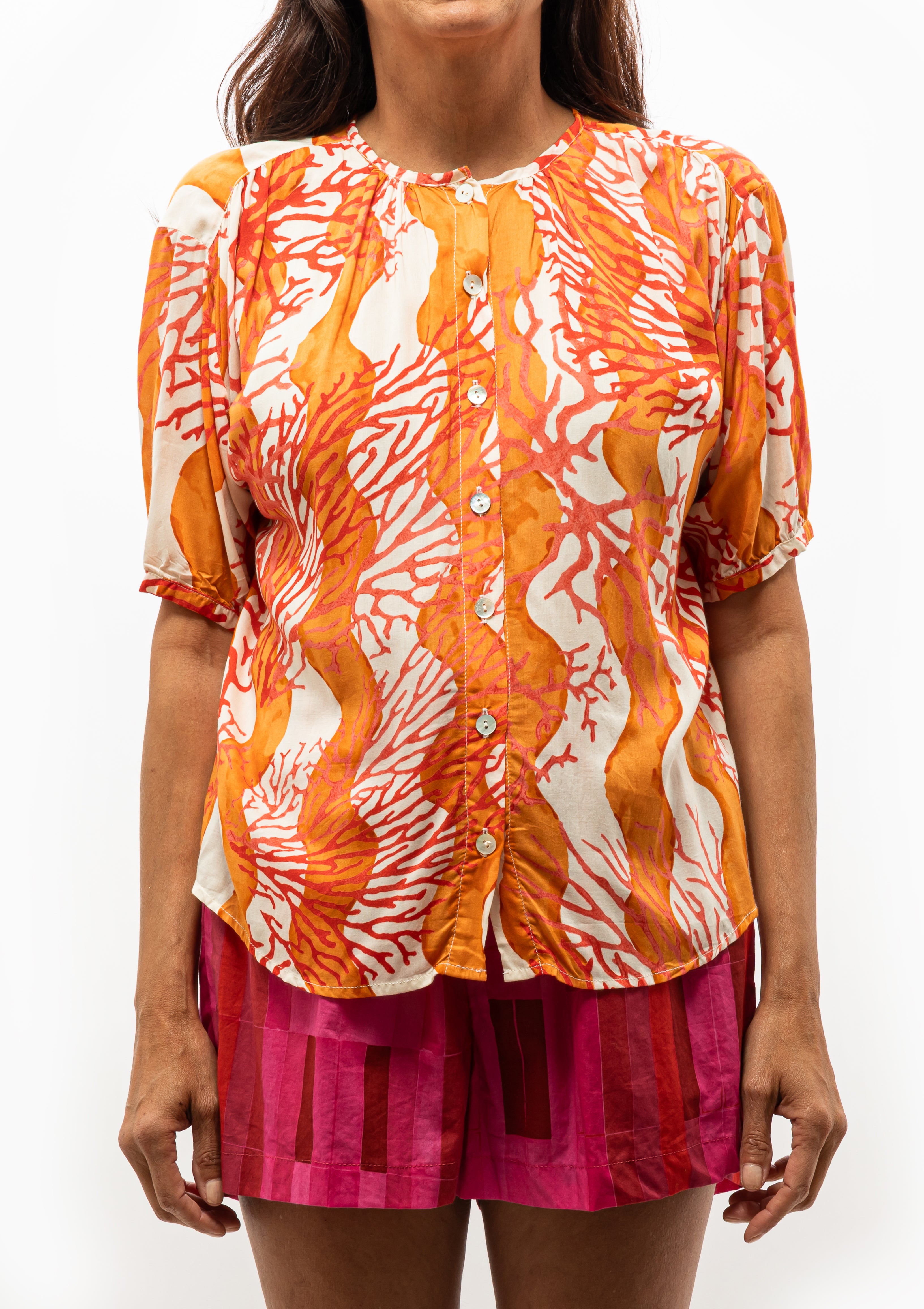 Natalie Martin’s Honey Wave Top in Coral, perfect for warm weather — find it at Diani Boutique.