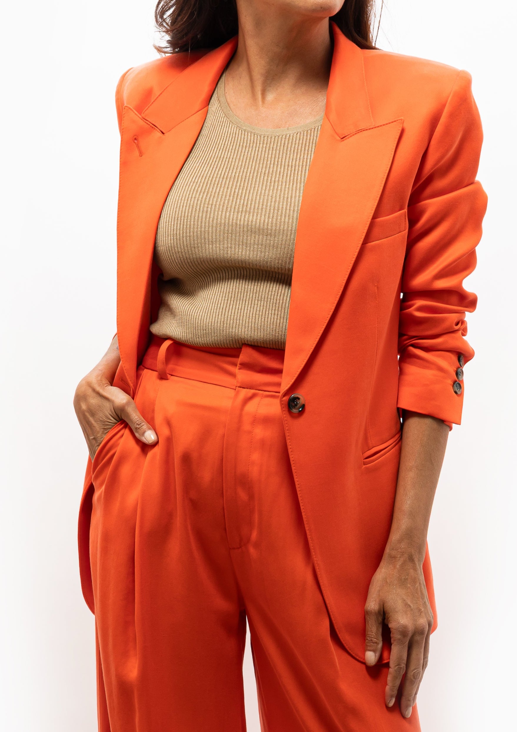 Woman wearing a bright orange blazer 90's Blazer in Vermillion by Smythe with matching trousers. Available at Diani Boutique.