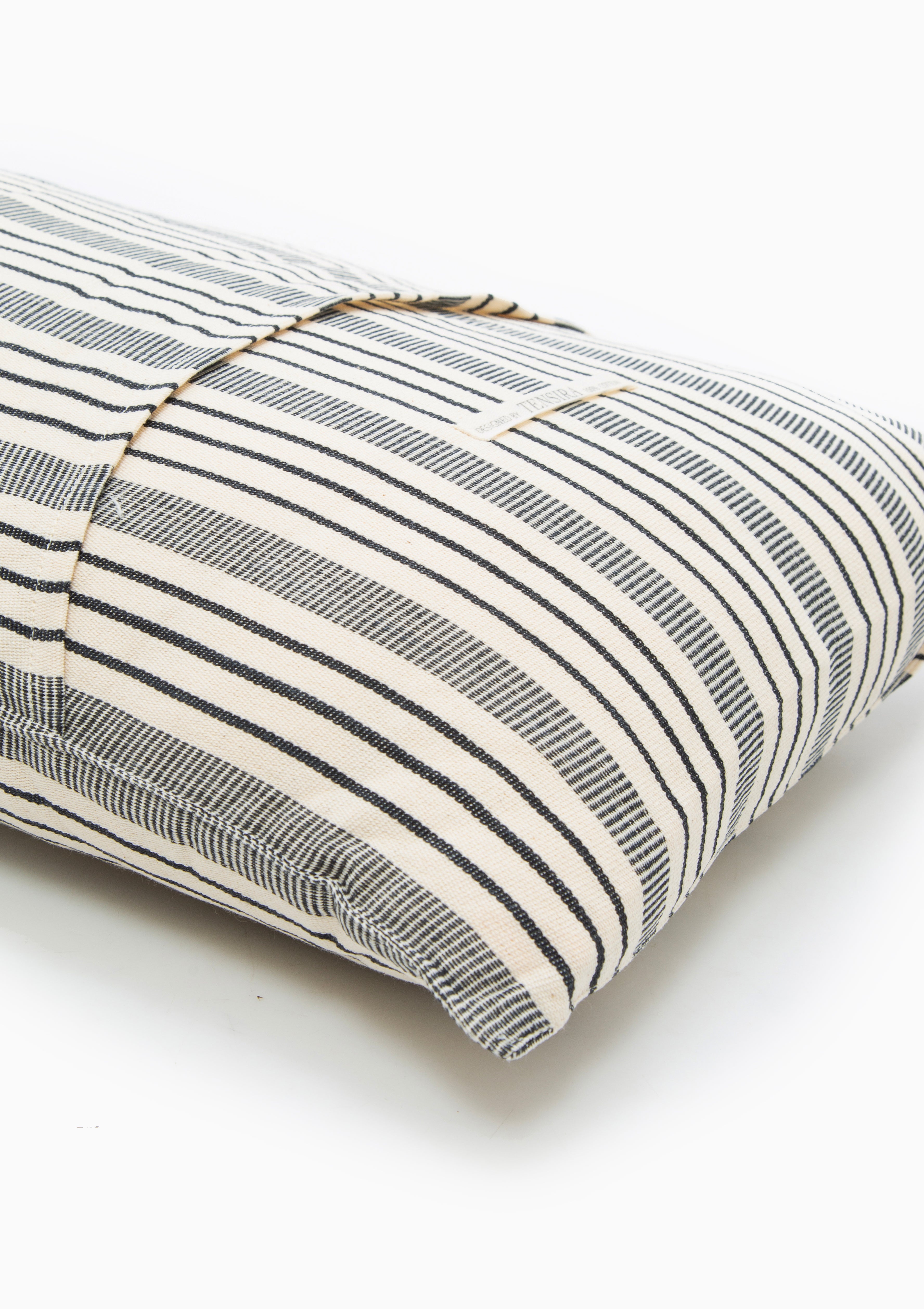 Hand-dyed long cushions with minimalist stripes and natural tones, made on traditional looms from 100% cotton by Tensira artisans.