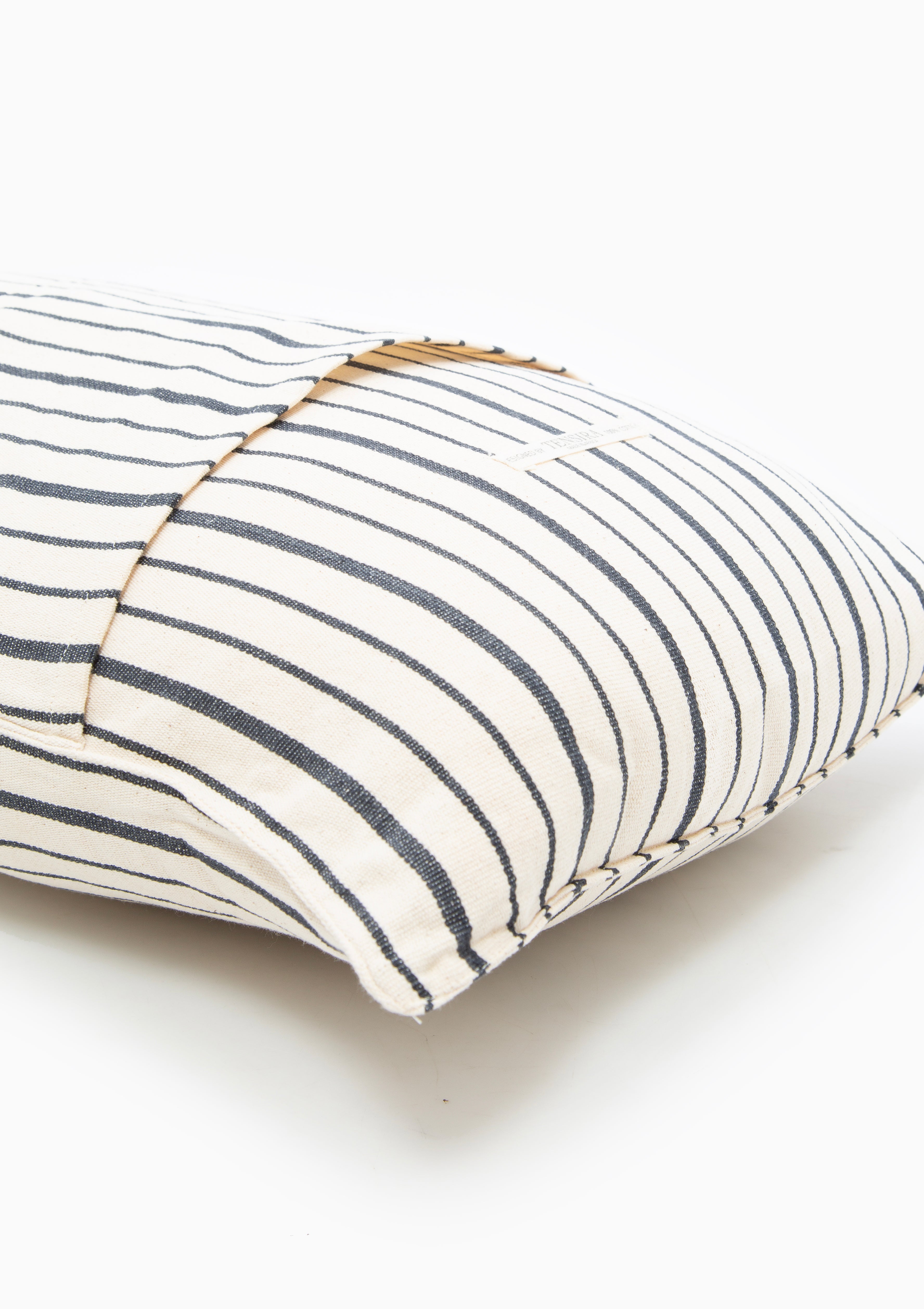 Eco-conscious long cushions in a mix of solid and striped patterns, featuring hand-dyed yarns and artisan-made cotton fabric from Guinea. Available at Diani Boutique.