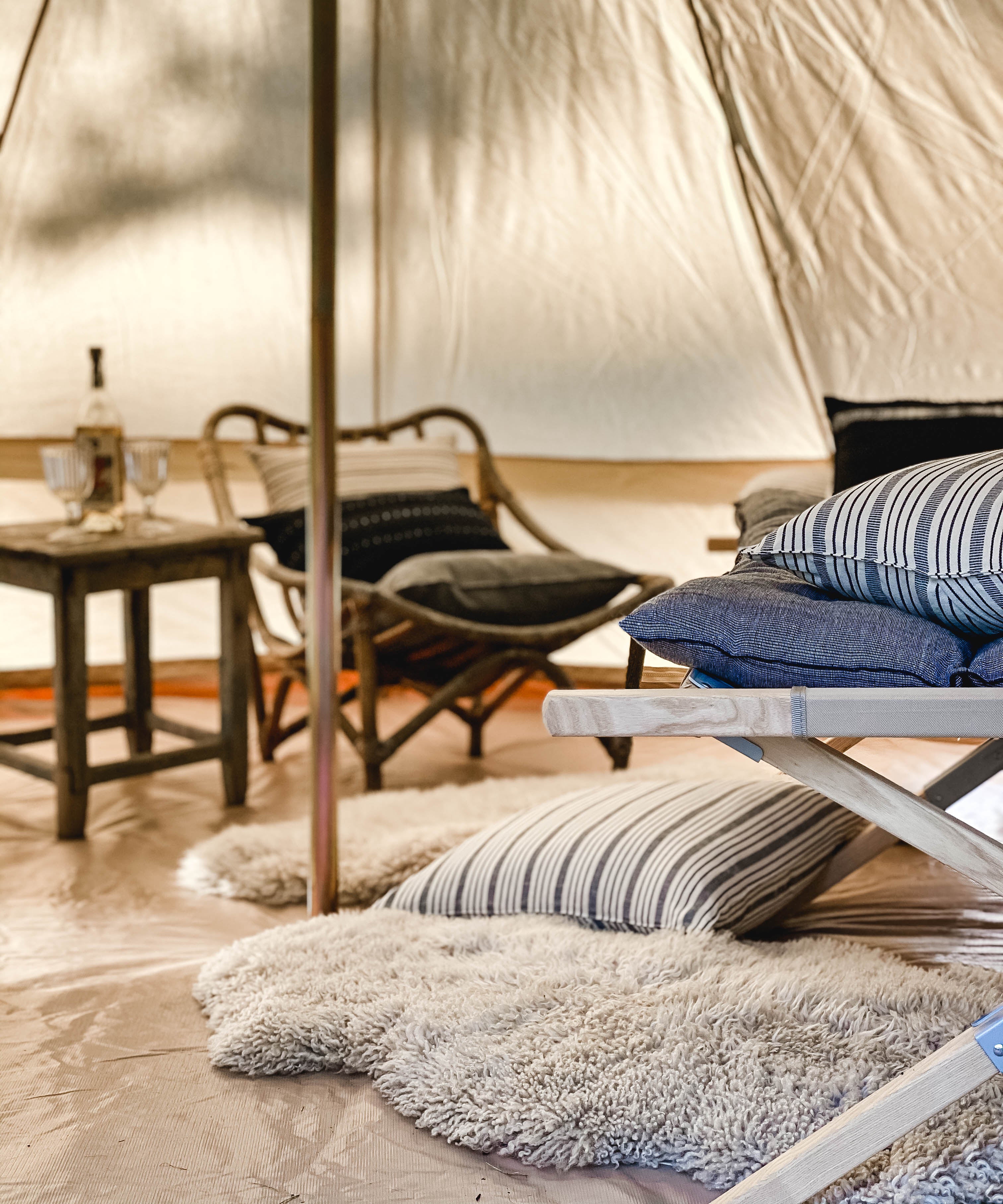 Tensira headboard cushion in soft, natural tones, featuring hand-dyed yarns and traditional weaving techniques, shown in our outdoor tent to elevate your garden campout experience.