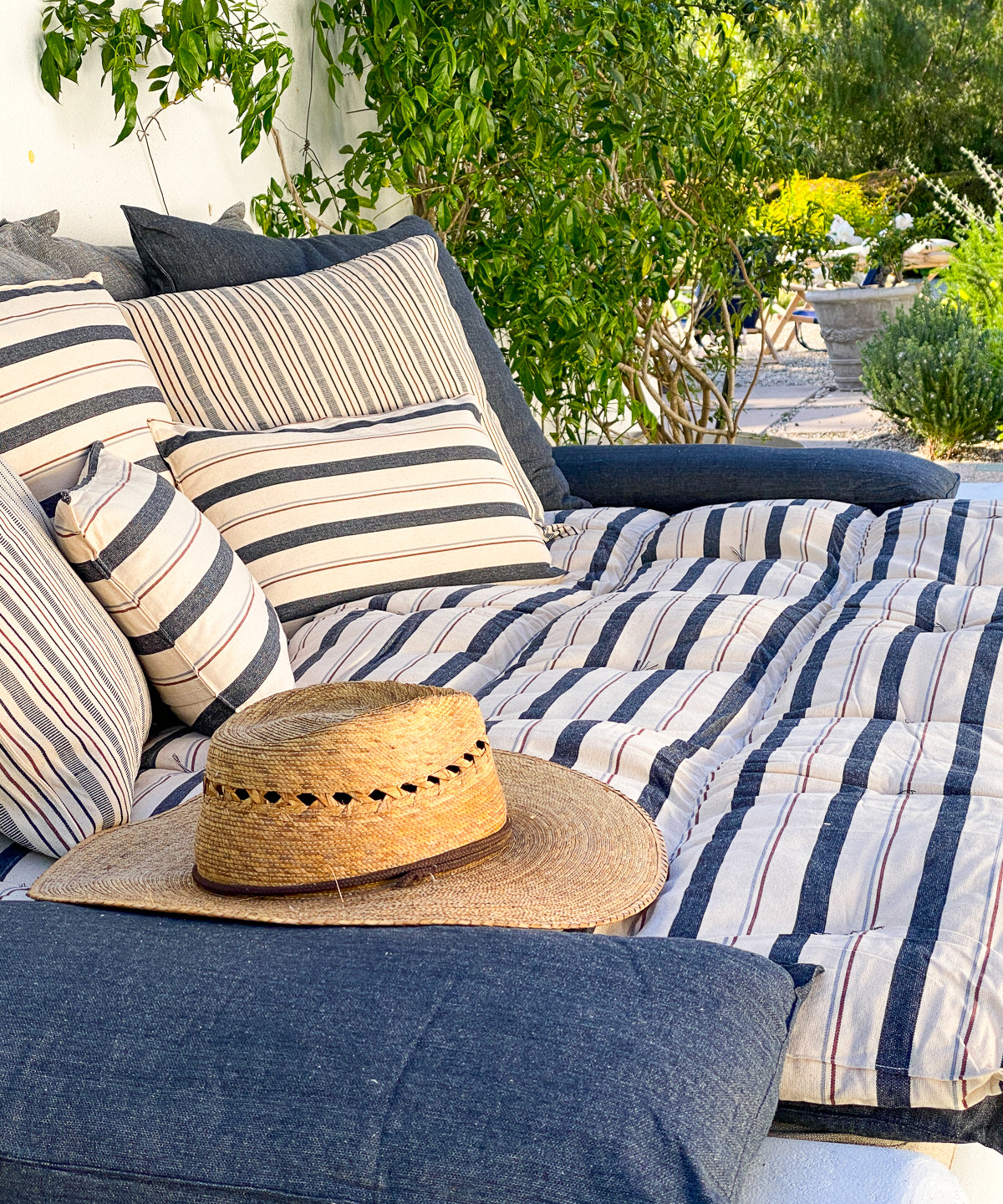 Striped cotton bed roll from the DIANI x Tensira collection, ideal for relaxed garden picnics and sustainable outdoor living.