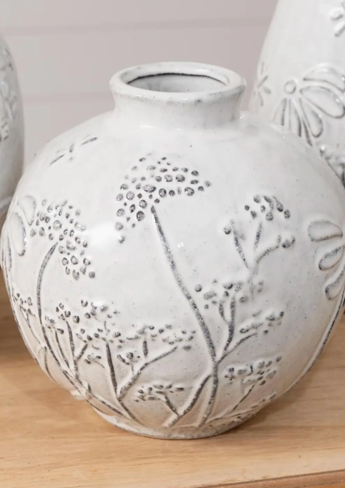 Short white vase with a debossed textured pattern, filled with fresh flowers; a clean, modern decorative piece that adds a soft, sculptural touch to any space, available at Diani.