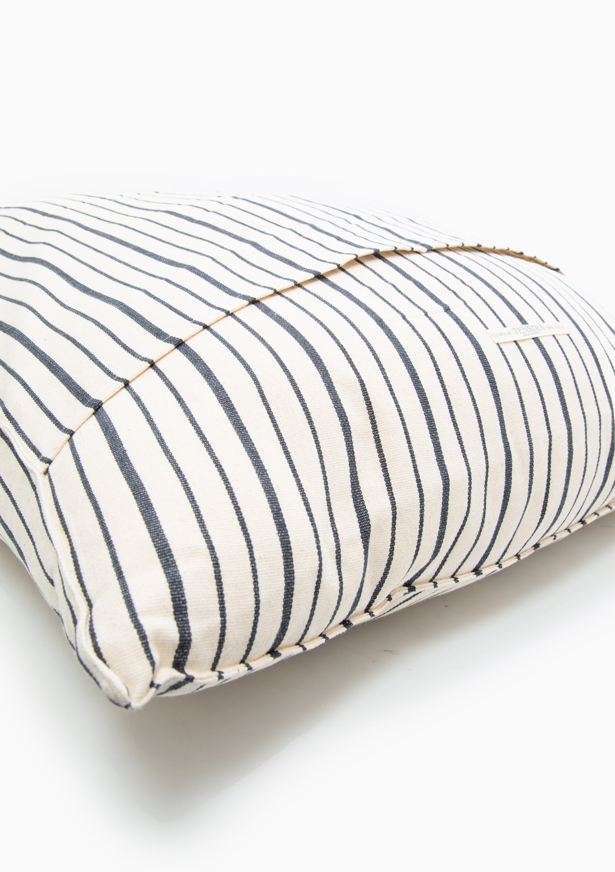 Close up of our removable striped cotton headboard cushion from Tensira, sustainably made in Guinea by artisan groups using zero-waste practices.