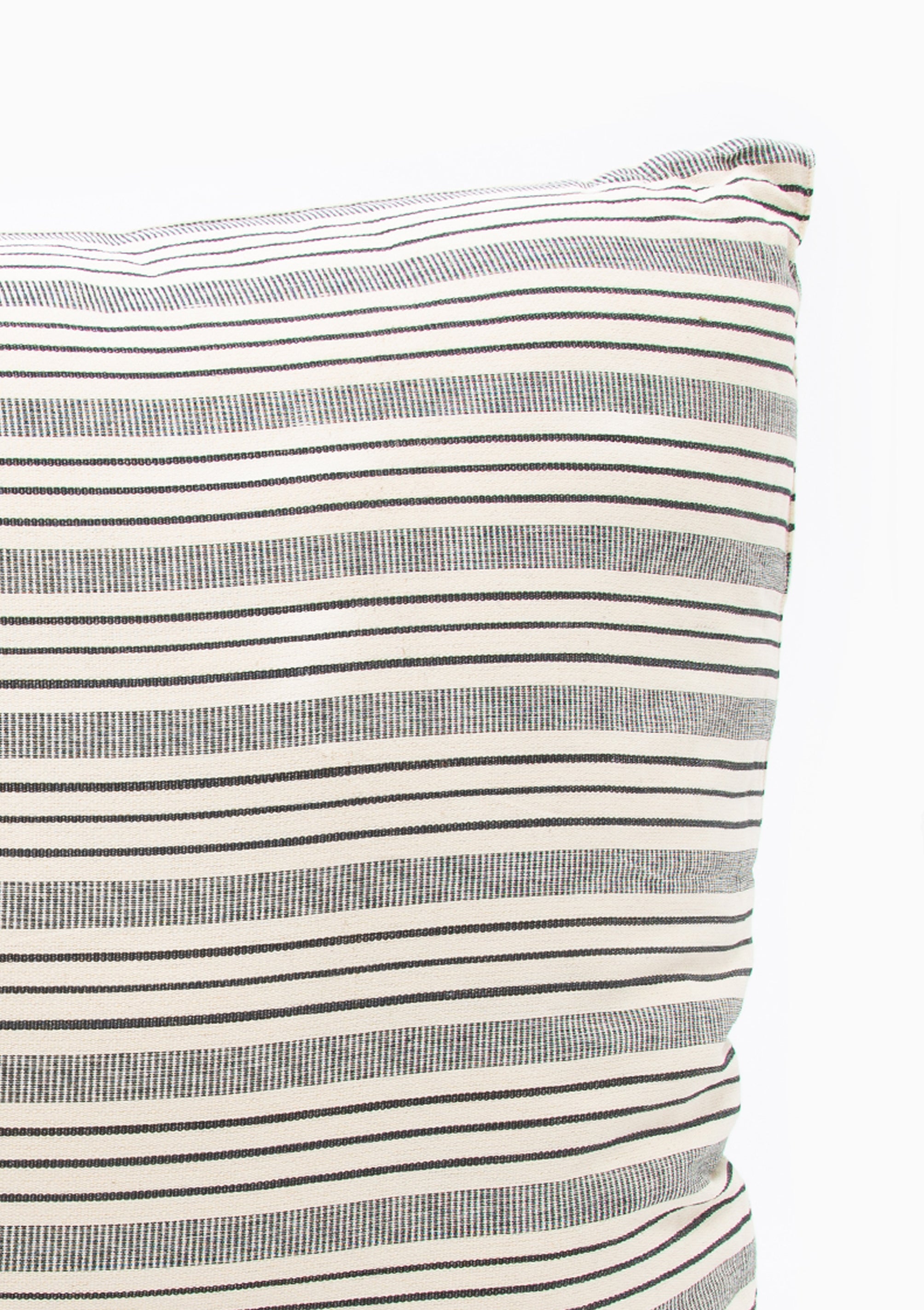 Close up of our striped cotton headboard cushion from Tensira, sustainably made in Guinea by artisan groups using zero-waste practices.