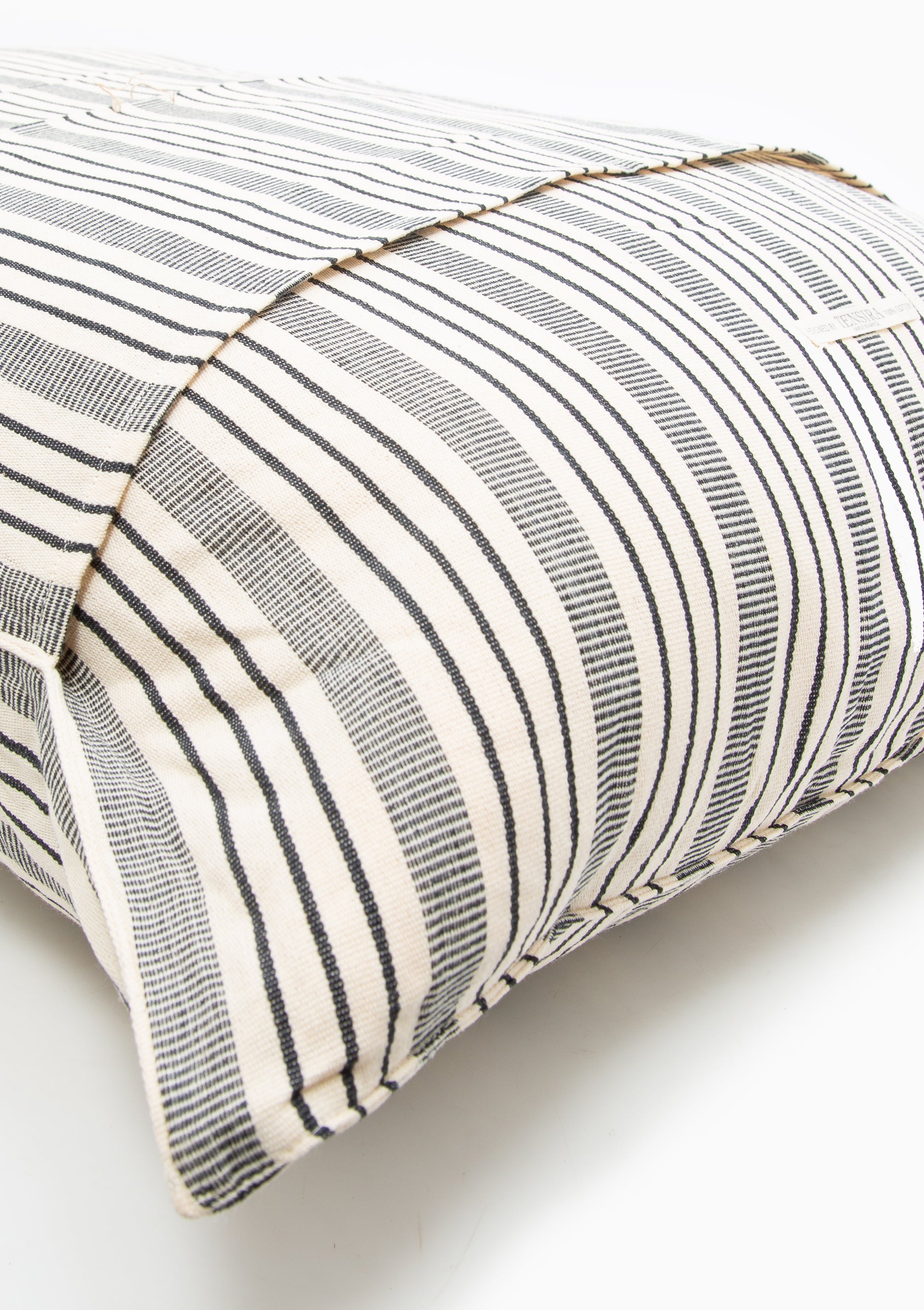 Close up of our striped cotton headboard cushion from Tensira, sustainably made in Guinea by artisan groups using zero-waste practices.