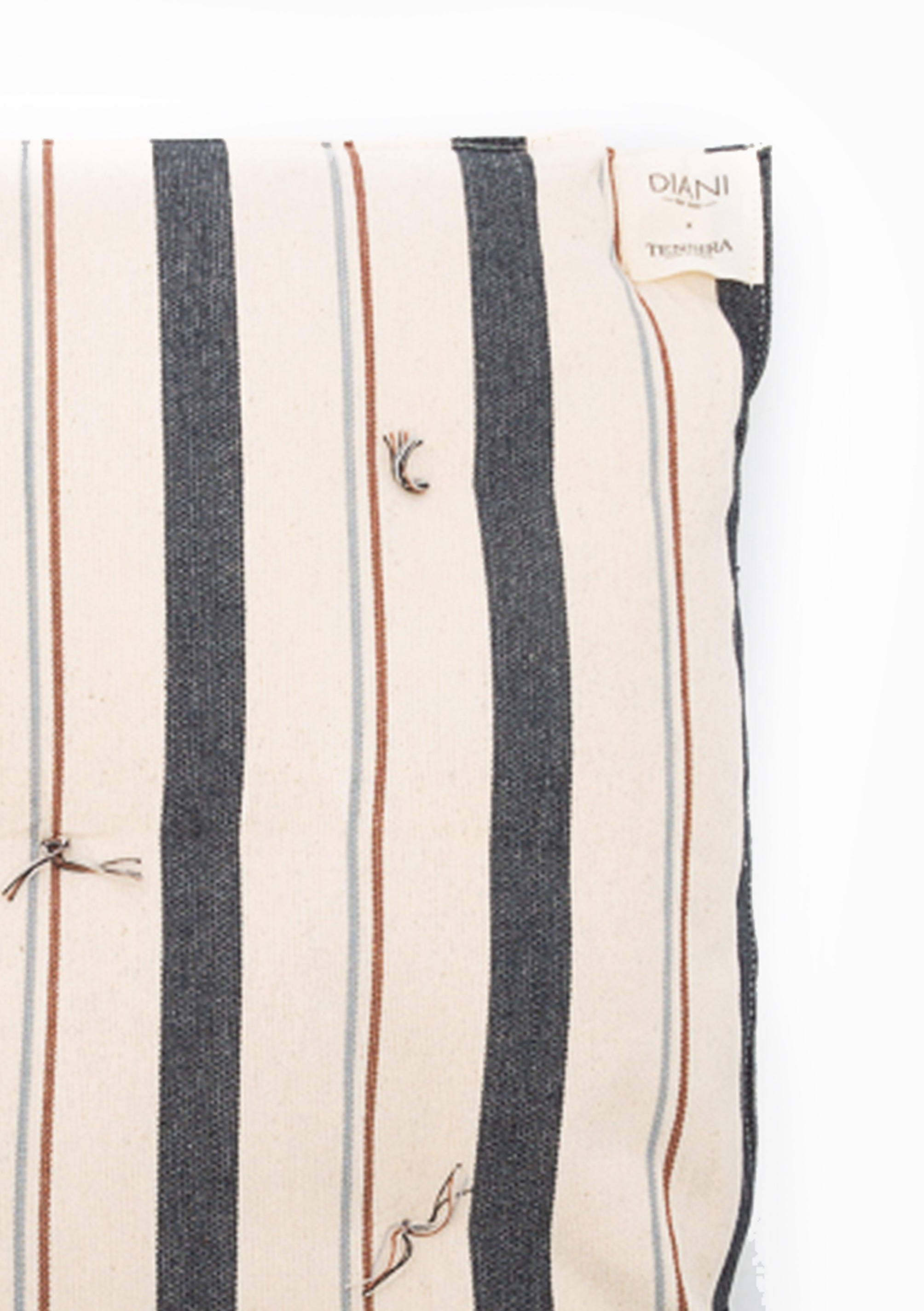 Eco-friendly tufted cushion in a striped design, crafted from hand-dyed cotton by artisans in Guinea for the Tensira x DIANI collaboration.
