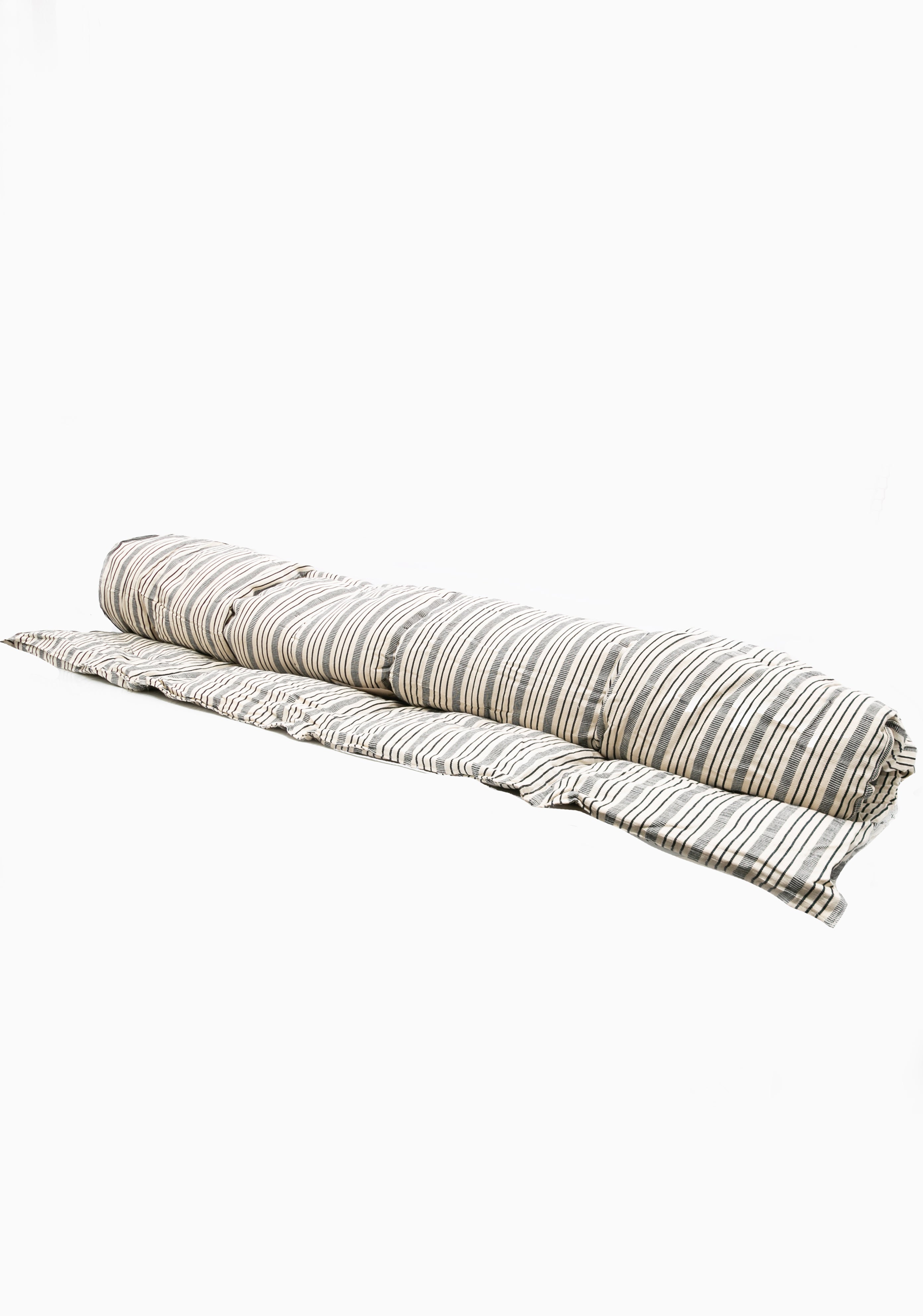 Striped cotton bed roll from the DIANI x Tensira collection, ideal for relaxed garden picnics and sustainable outdoor living.