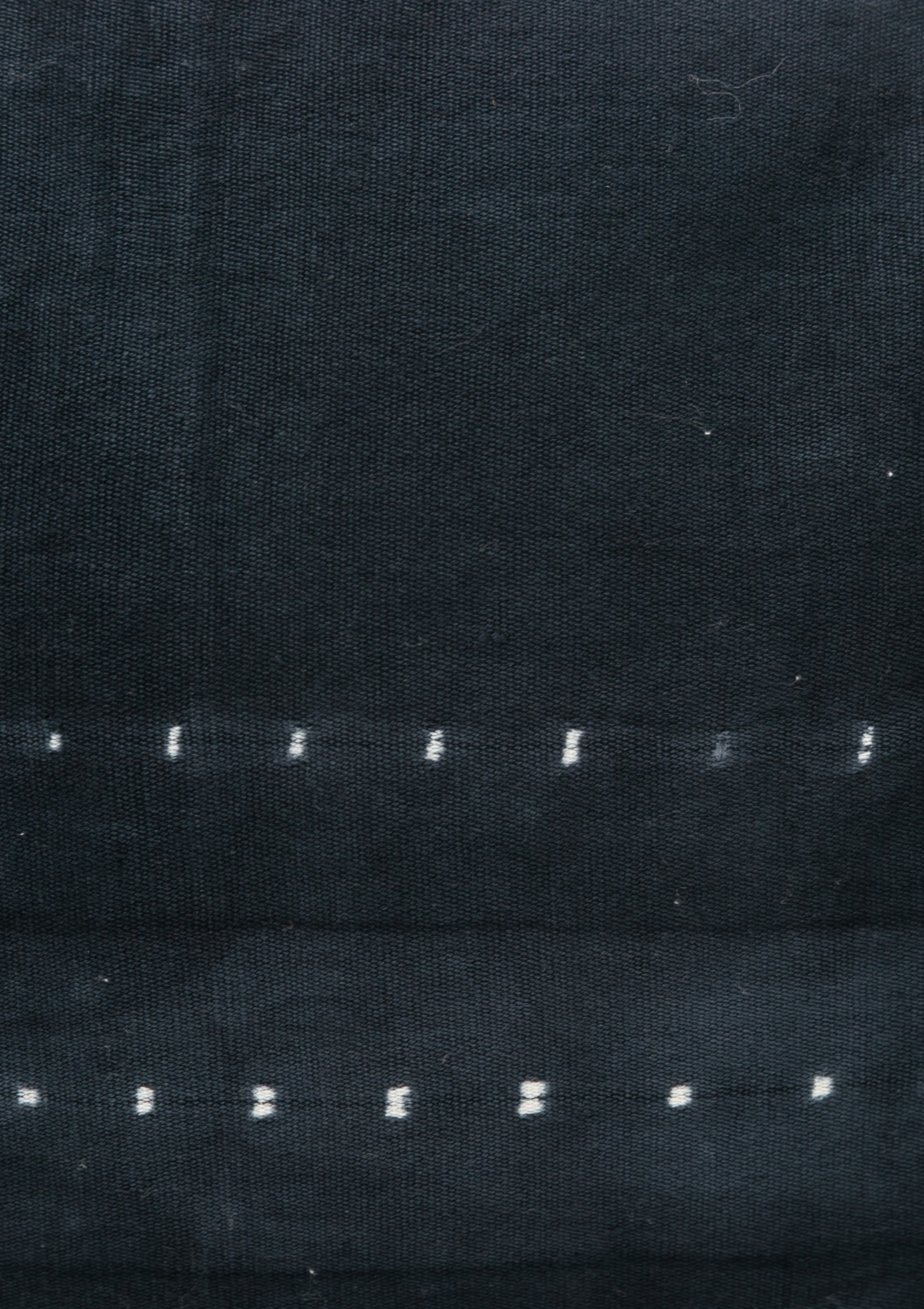 Long navy bolster pillow featuring a hand-dyed dot batik pattern, made from artisan-crafted cotton in a 14" x 48" size.