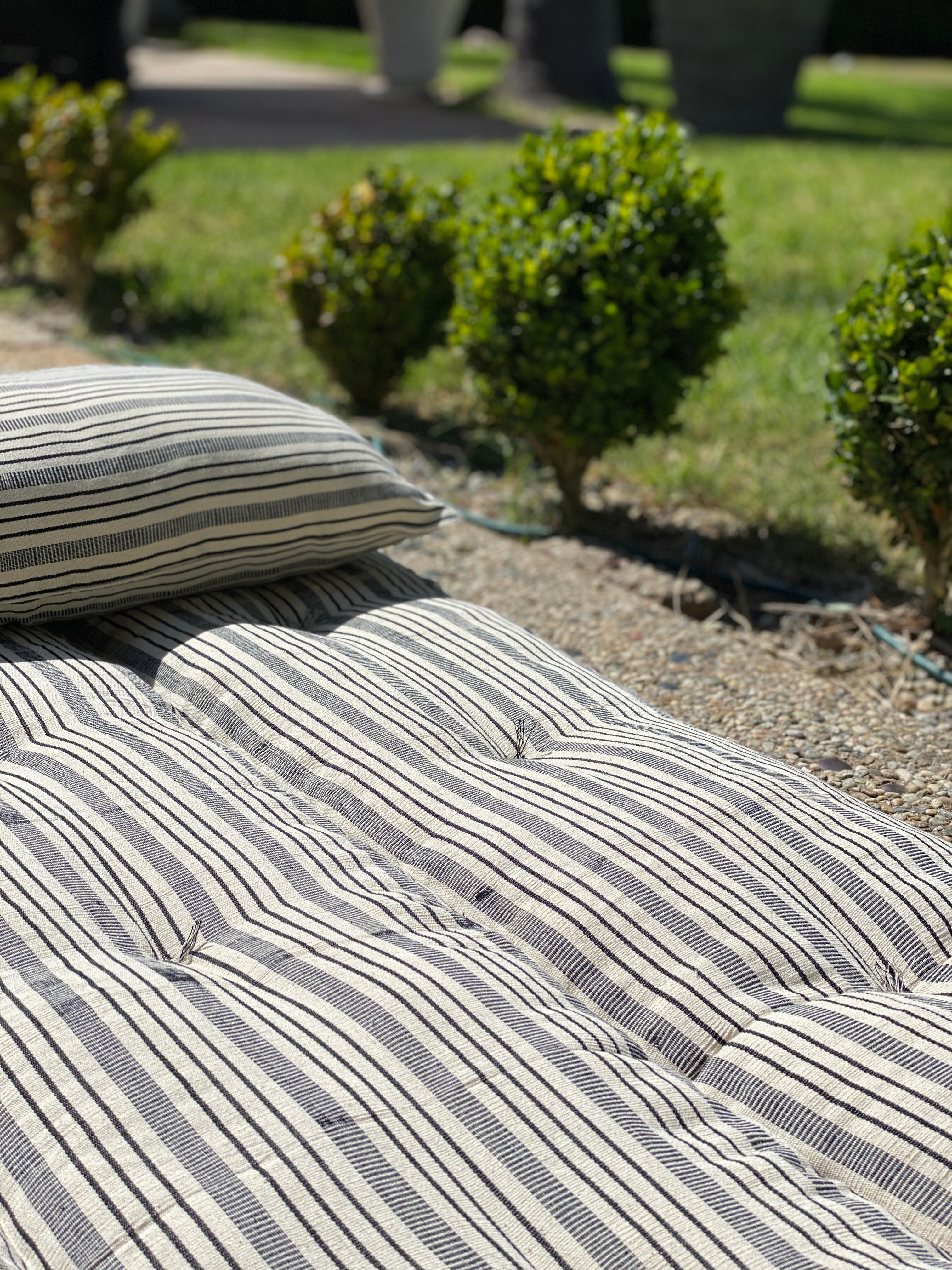 Striped cotton bed roll from the DIANI x Tensira collection, ideal for relaxed garden picnics and sustainable outdoor living.