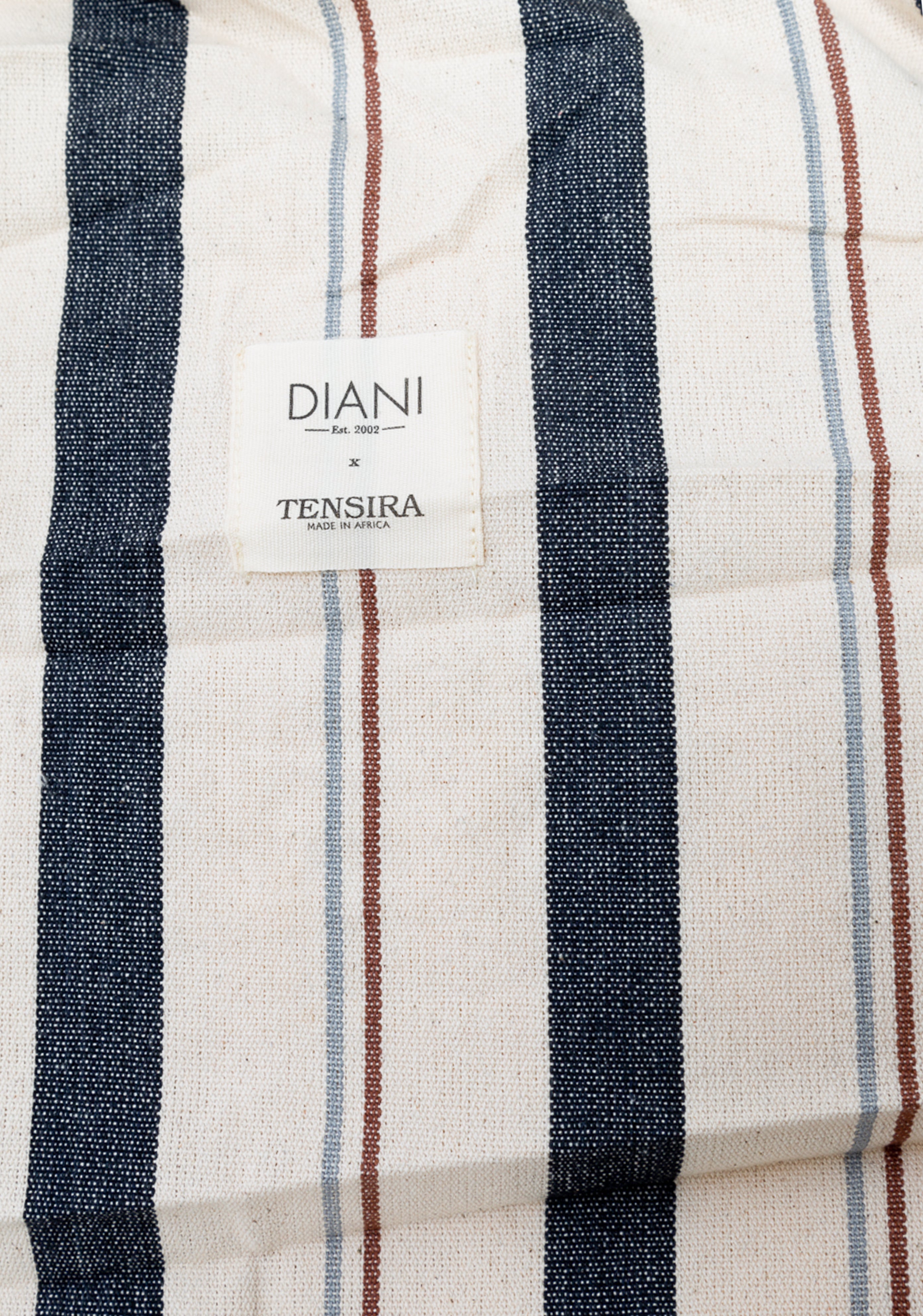 Closeup of the lightweight and portable bed roll featuring hand-dyed stripes, part of Caroline Diani’s globally inspired DIANI x Tensira line.