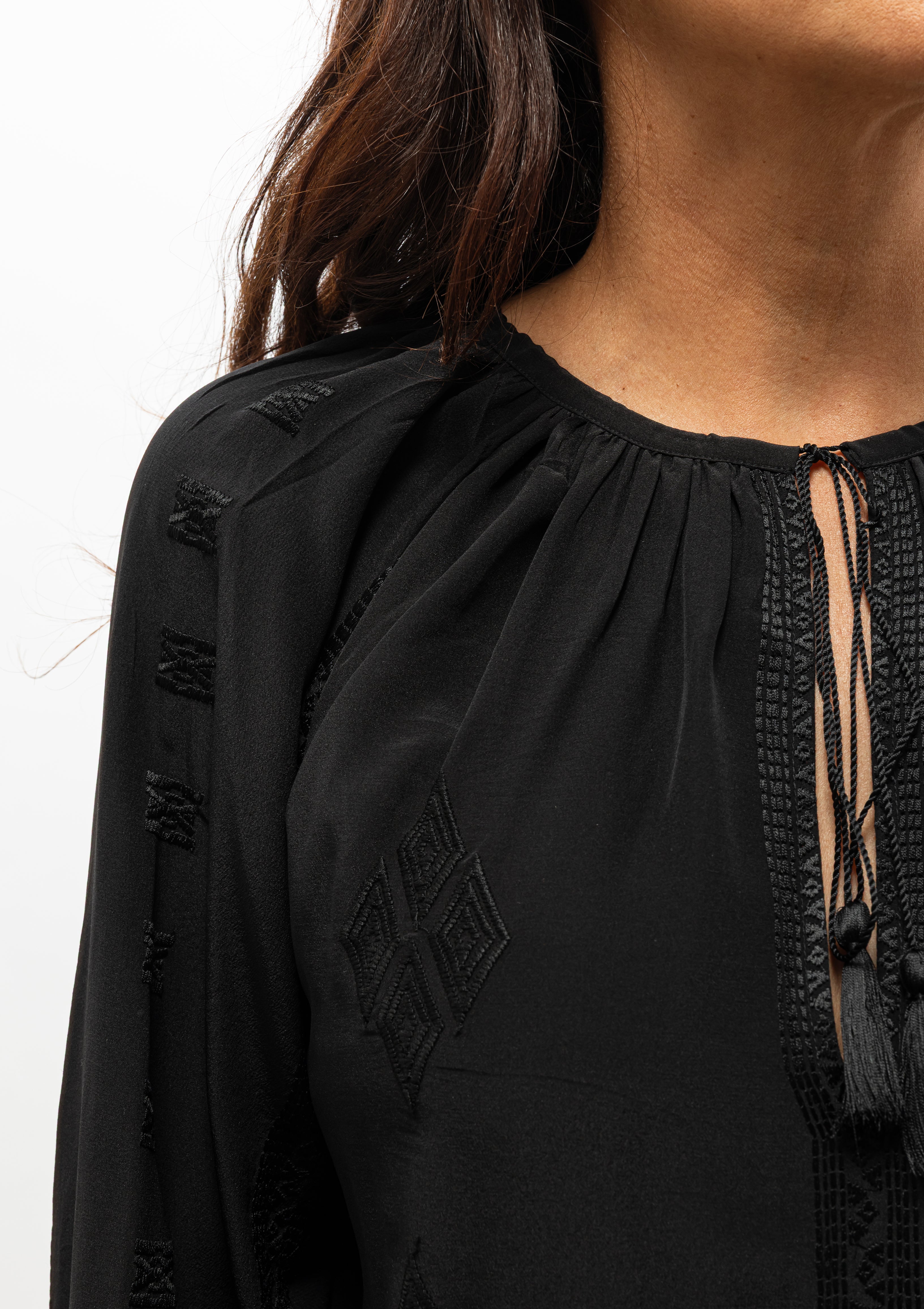 Nili Lotan Cristo Silk Blouse in classic black featuring tonal Indian embroidery and delicate tassel ties — available at Diani Boutique.