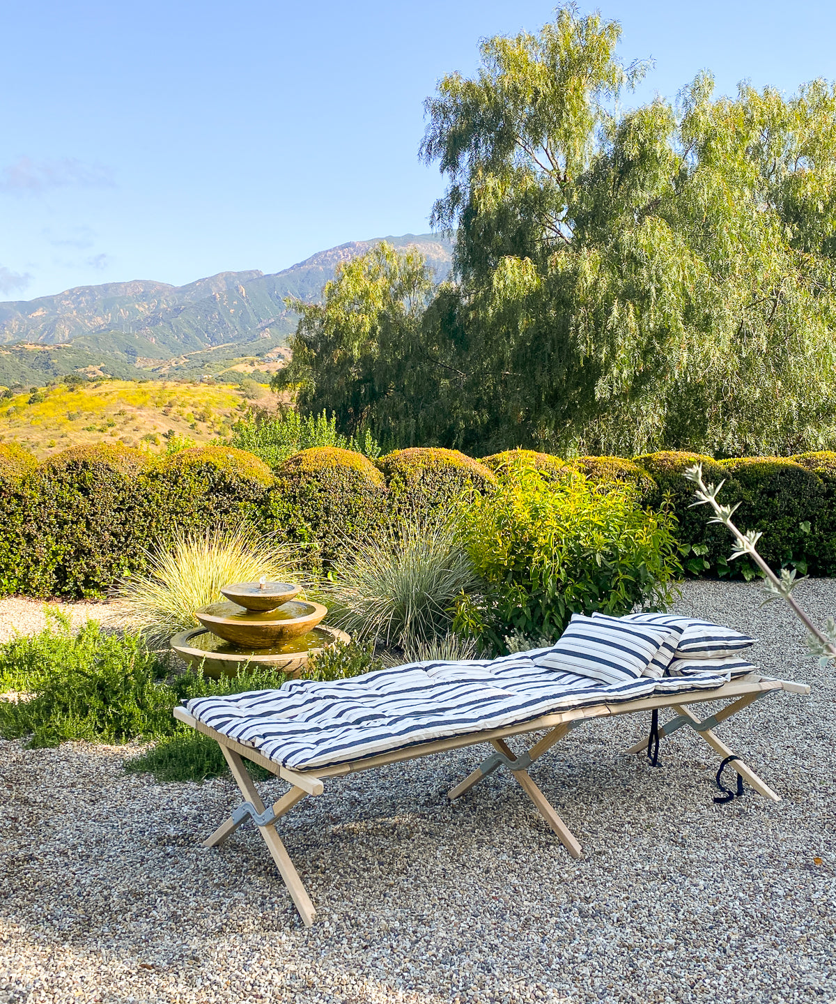Striped cotton bed roll from the DIANI x Tensira collection, ideal for relaxed garden picnics, afternoon naps, and sustainable outdoor living.
