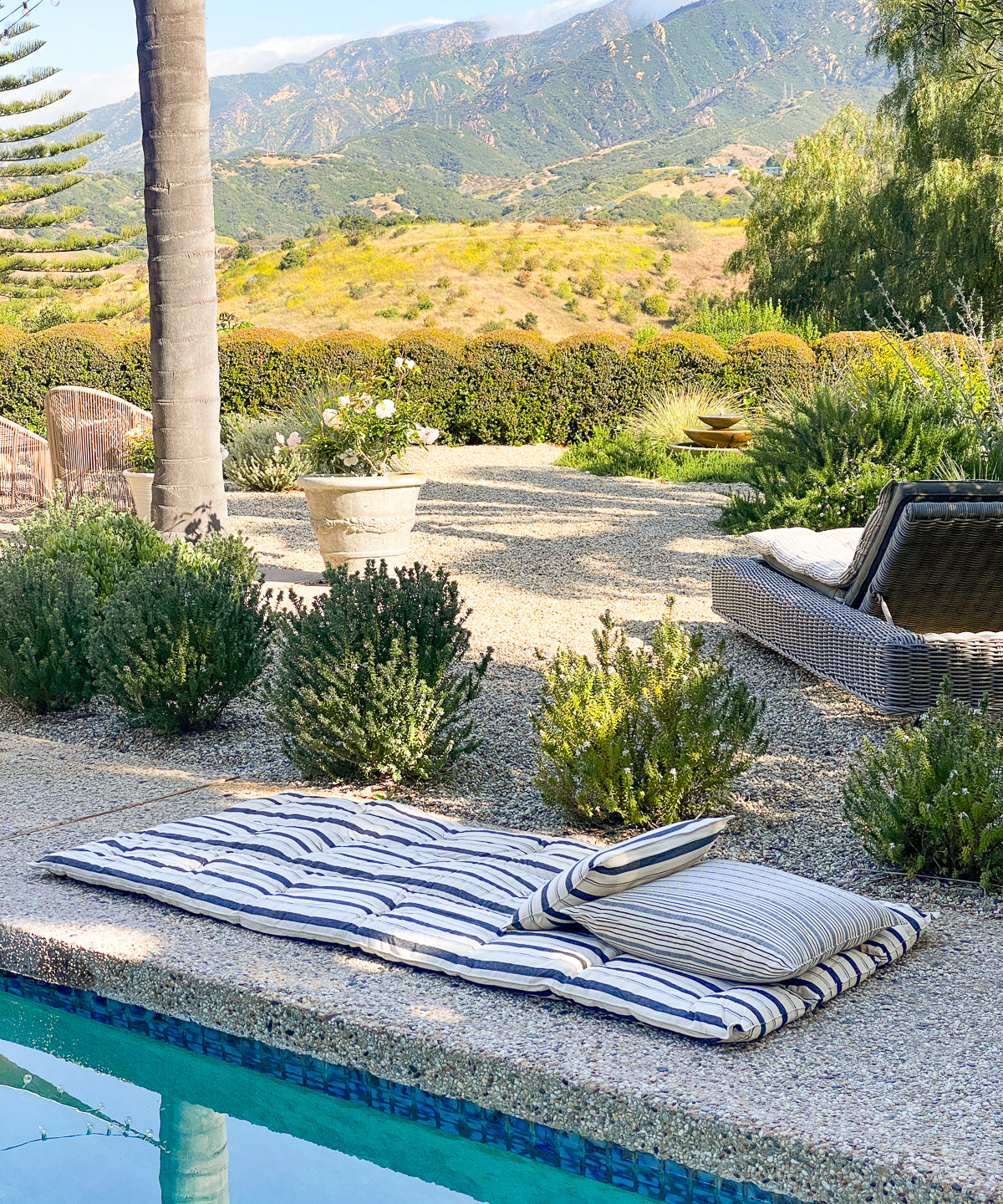 DIANI x Tensira striped cotton bed roll, perfect for garden picnics or outdoor lounging, made from handwoven, hand-dyed fabric inspired by Caroline Diani’s roots and global homes. Crafted in Guinea by artisan groups using sustainable, zero-waste practices.