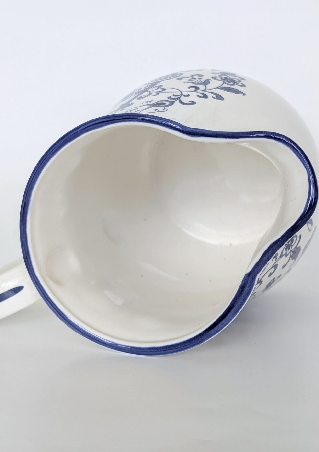 Top-down view of vintage ceramic pitcher with curved spout and glazed handle, featuring the Blue Garden pattern by Baker Hart & Stuart. Available at Diani Boutique.