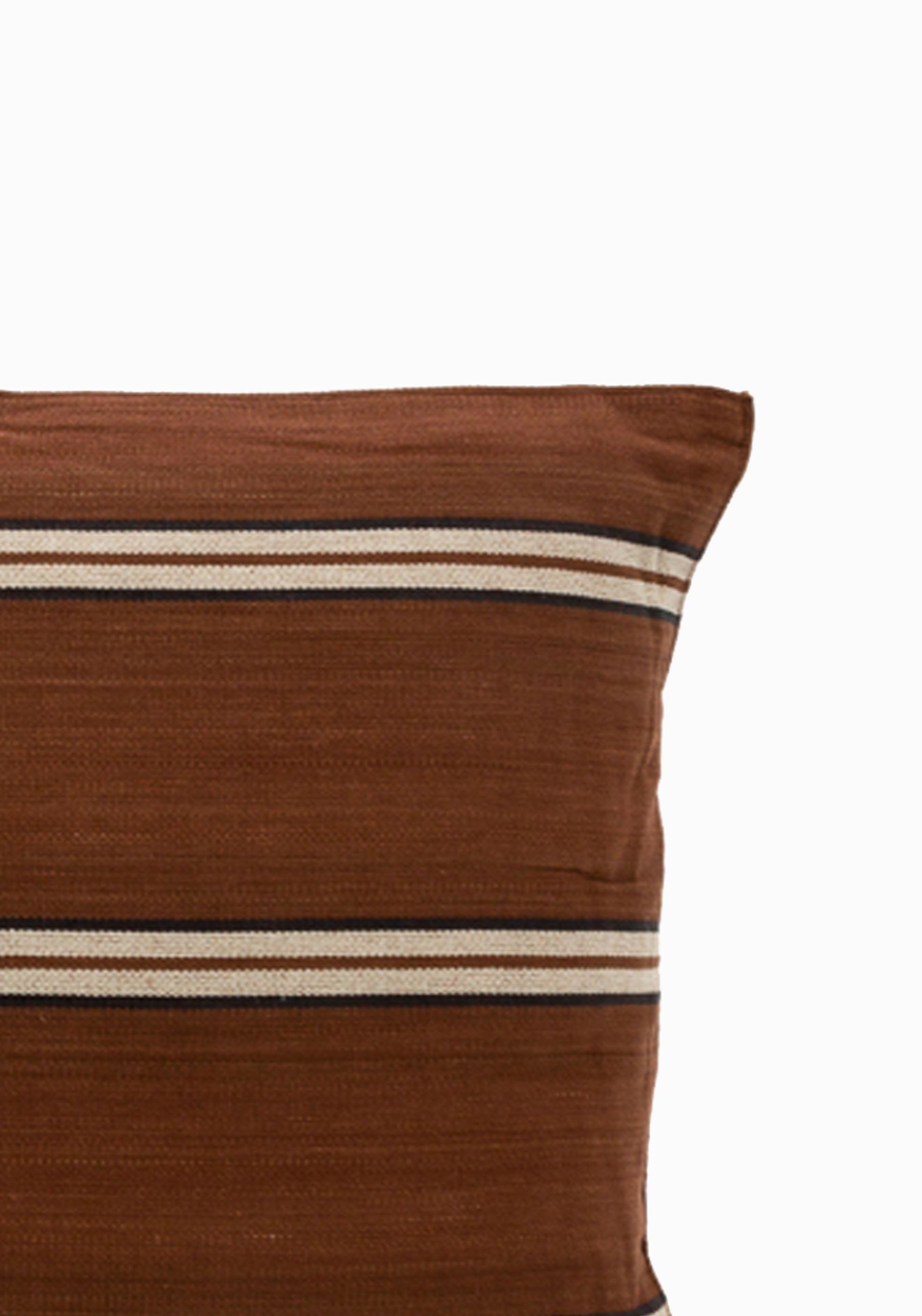 Inspired by safari landscapes, this 12" x 20" striped pillow features handwoven cotton in grounded, natural hues and traditional craftsmanship. Part of the Diani x Tensira Collaboration collection.