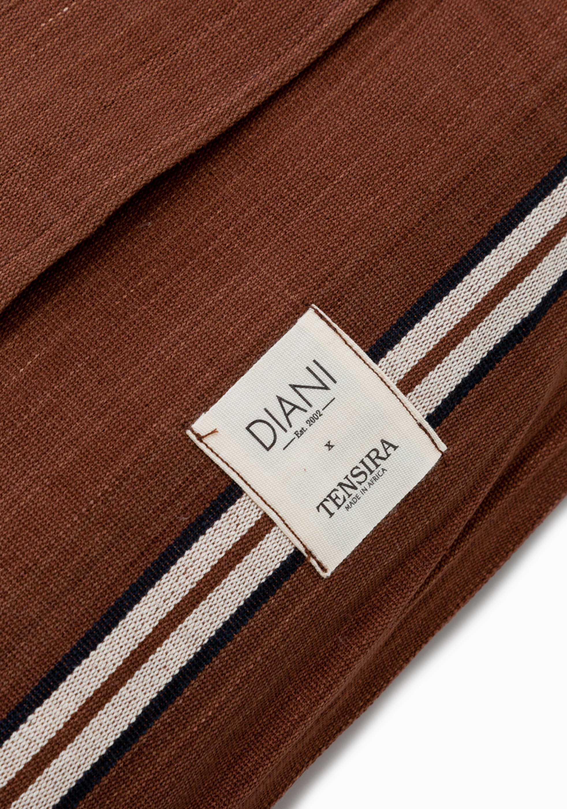 Inspired by safari landscapes, this 12" x 20" striped pillow features handwoven cotton in grounded, natural hues and traditional craftsmanship. Part of the Diani x Tensira Collaboration collection.